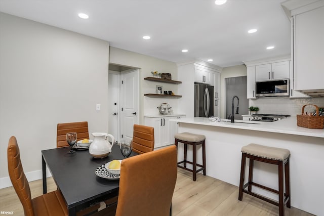 dining space with light hardwood / wood-style floors and sink