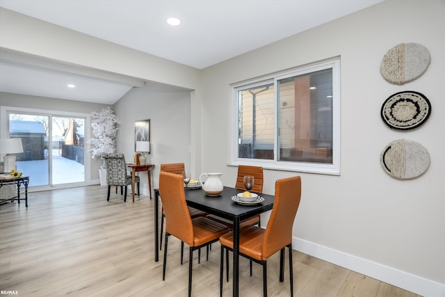 dining space featuring light hardwood / wood-style floors and vaulted ceiling