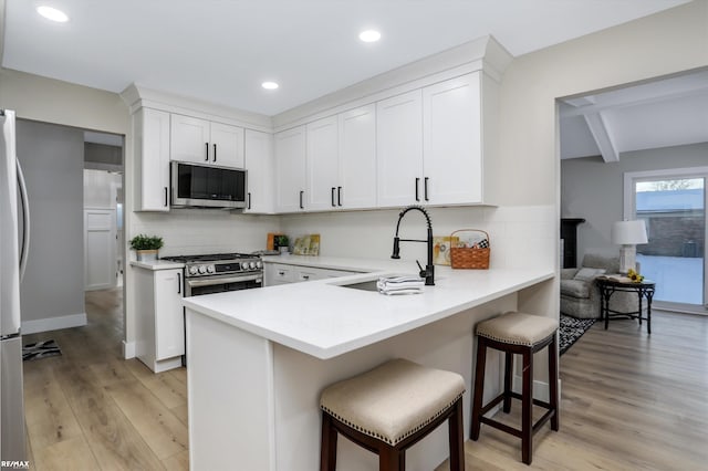 kitchen with white cabinets, stainless steel appliances, backsplash, and sink