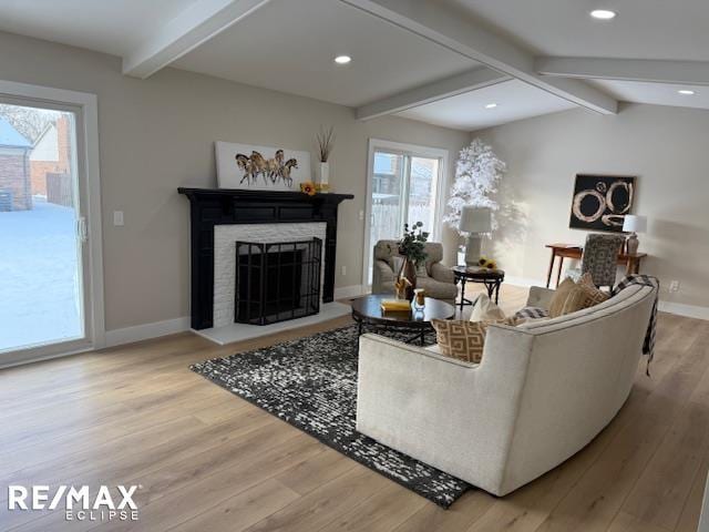 living room featuring vaulted ceiling with beams and hardwood / wood-style flooring