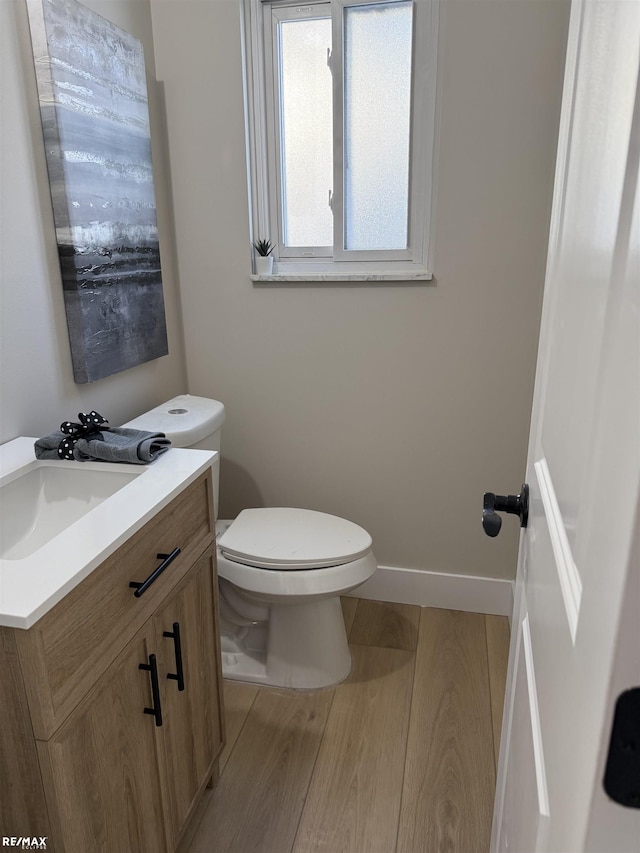 bathroom with toilet, hardwood / wood-style flooring, and vanity