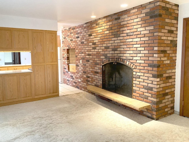 unfurnished living room with light carpet and a brick fireplace