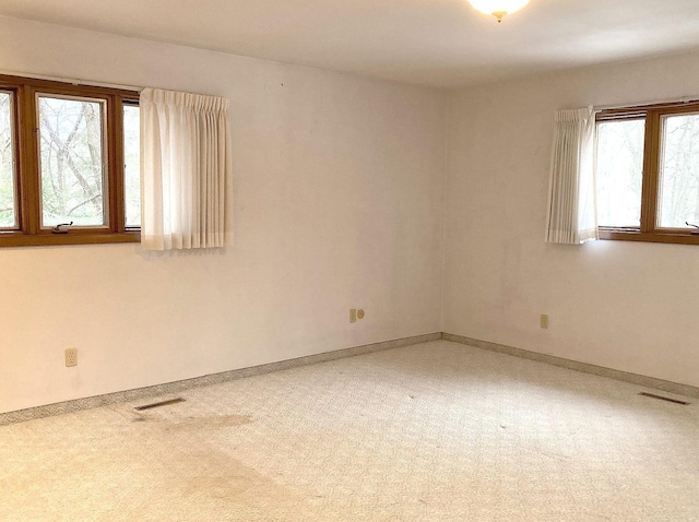 spare room featuring a wealth of natural light and carpet flooring