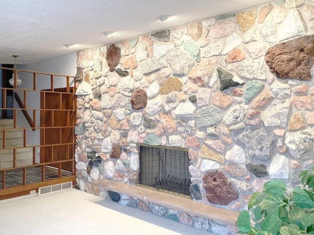 room details with a stone fireplace and a textured ceiling