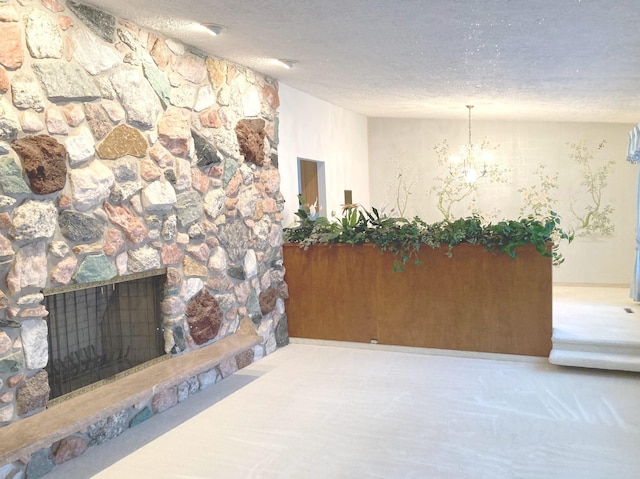 unfurnished living room with a textured ceiling, an inviting chandelier, and a stone fireplace