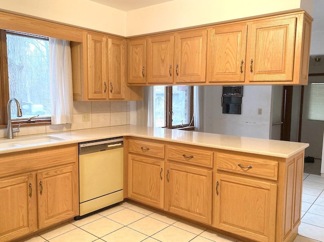 kitchen featuring white dishwasher, sink, kitchen peninsula, and a healthy amount of sunlight