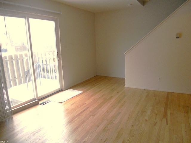 spare room with light hardwood / wood-style floors and plenty of natural light