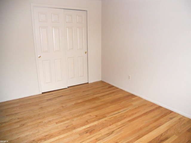 unfurnished bedroom featuring a closet and light hardwood / wood-style floors