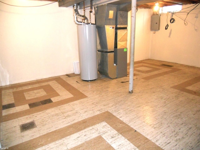 basement featuring electric panel, heating unit, and water heater