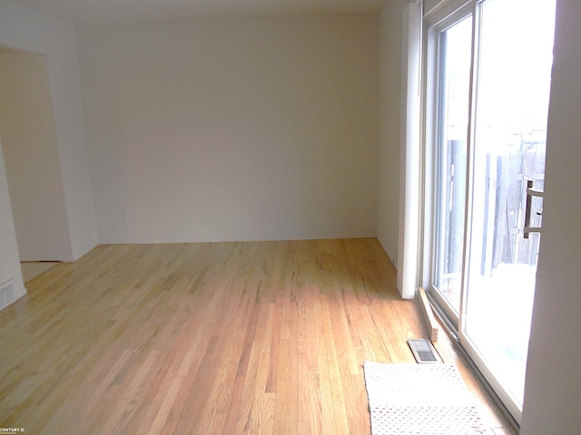 unfurnished room with light wood-type flooring and plenty of natural light