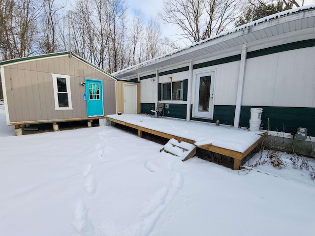 snow covered deck featuring an outdoor structure