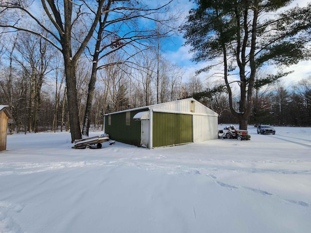 snow covered structure featuring a garage