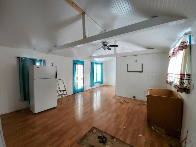 unfurnished living room featuring ceiling fan, lofted ceiling with beams, and hardwood / wood-style floors