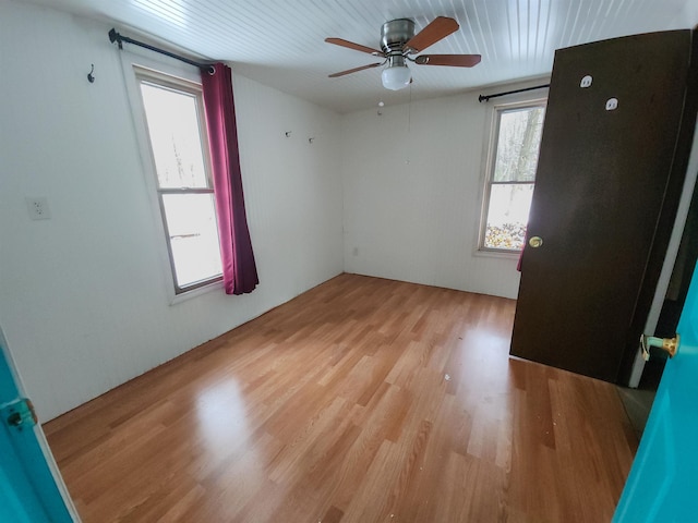 spare room featuring ceiling fan, a healthy amount of sunlight, and light hardwood / wood-style flooring