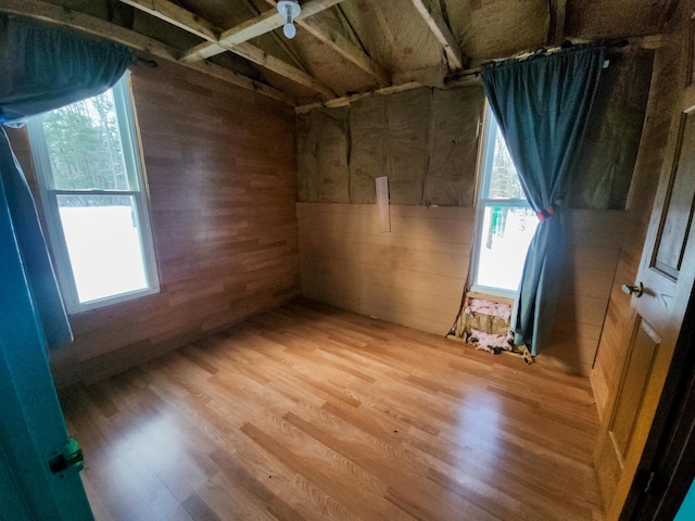 spare room featuring hardwood / wood-style flooring and wooden walls