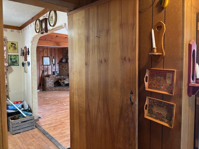 hallway with a textured ceiling and hardwood / wood-style floors