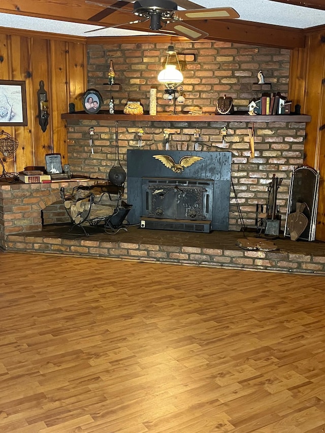 unfurnished living room featuring wood walls, light hardwood / wood-style floors, and a wood stove