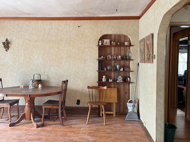 dining space featuring hardwood / wood-style flooring and crown molding