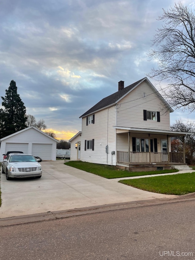 view of front of property with a porch, a lawn, a garage, and an outdoor structure