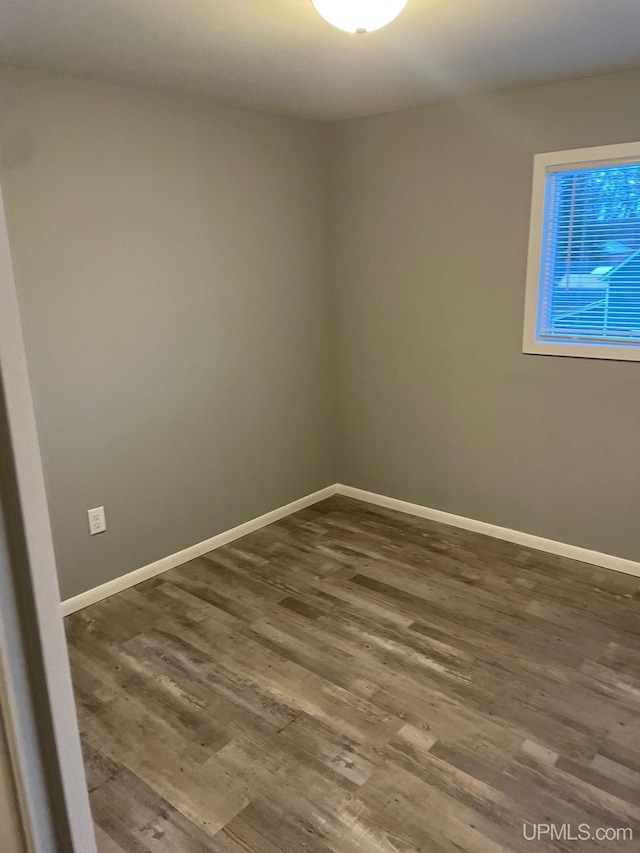 unfurnished room with dark hardwood / wood-style flooring