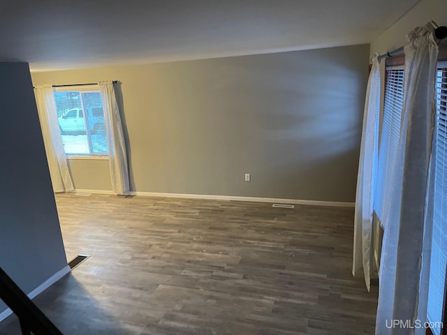 unfurnished room with dark wood-type flooring