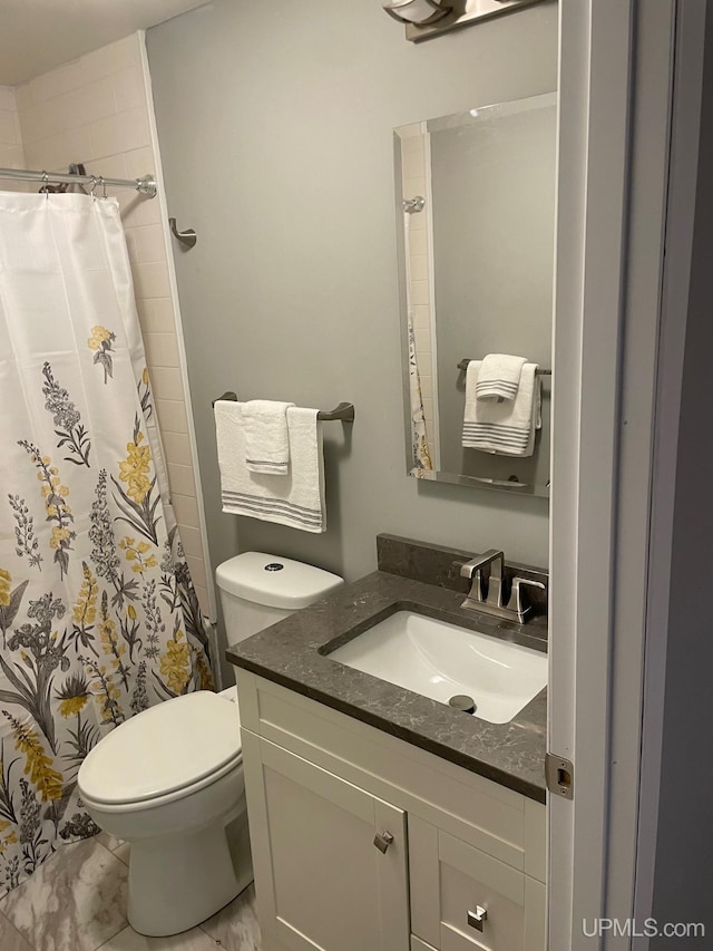 bathroom with toilet, vanity, and a shower with curtain