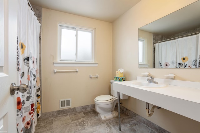 bathroom with sink, plenty of natural light, and toilet