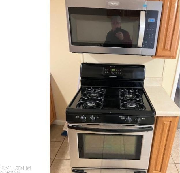 kitchen with light tile patterned flooring and appliances with stainless steel finishes