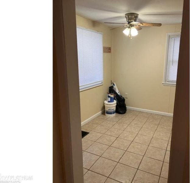 tiled spare room featuring ceiling fan