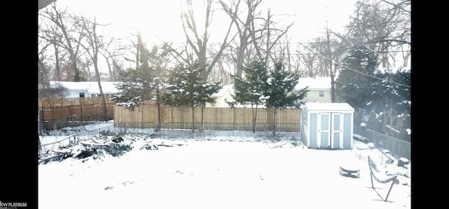 snowy yard with a storage shed