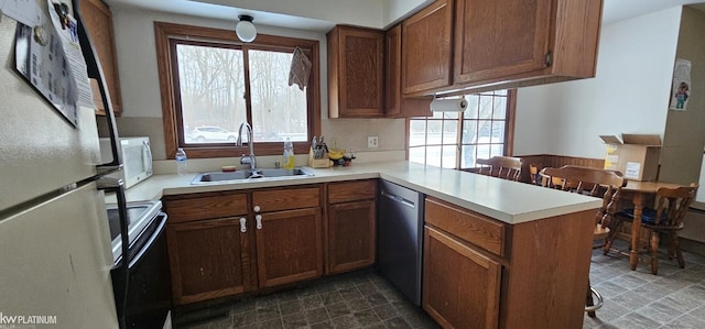 kitchen featuring white appliances, kitchen peninsula, and sink