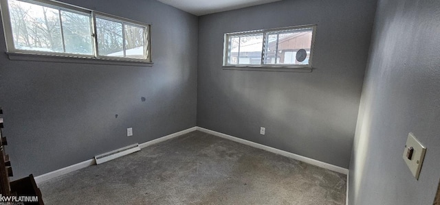 spare room featuring a baseboard radiator, carpet flooring, and plenty of natural light