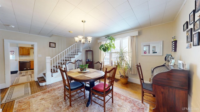 dining area with an inviting chandelier and light hardwood / wood-style flooring