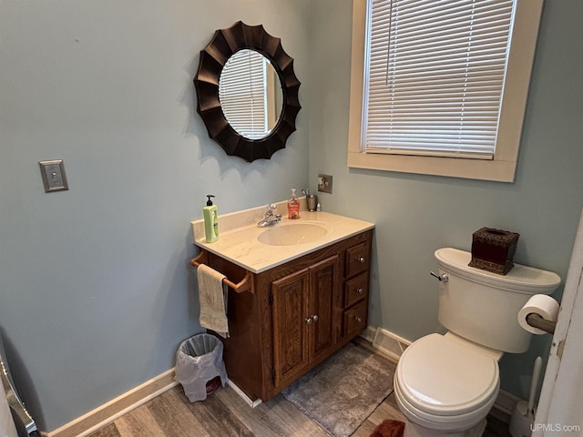 bathroom with hardwood / wood-style floors, toilet, and vanity