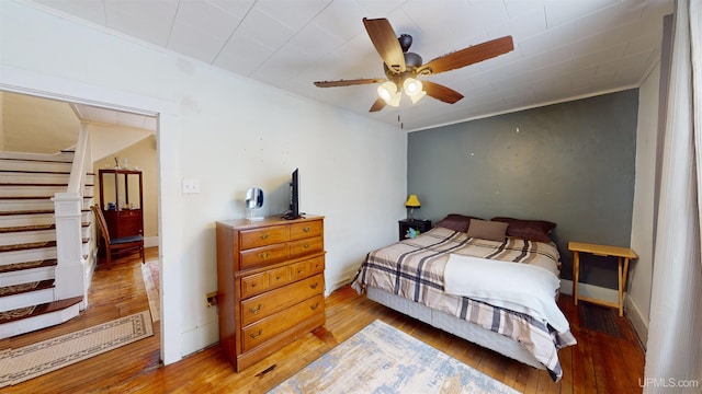 bedroom featuring ornamental molding, ceiling fan, and light hardwood / wood-style flooring