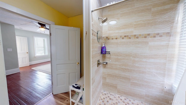 bathroom featuring ceiling fan and tiled shower