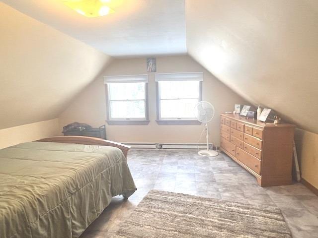 bedroom with a baseboard heating unit and vaulted ceiling