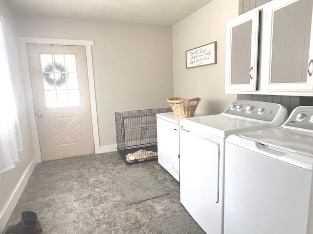 laundry room featuring separate washer and dryer and cabinets