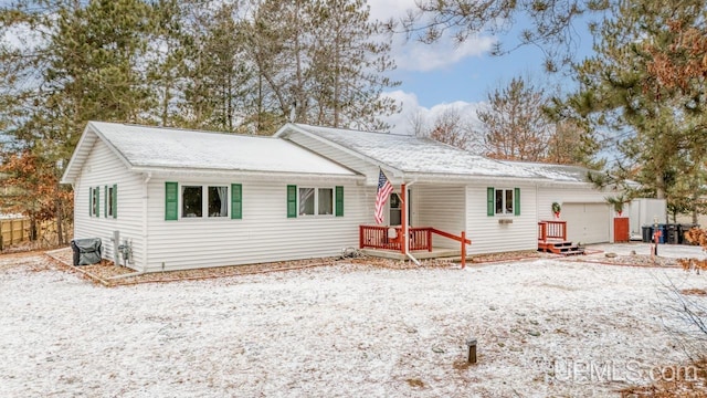 snow covered house featuring a garage