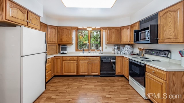 kitchen featuring white appliances, light hardwood / wood-style floors, and sink