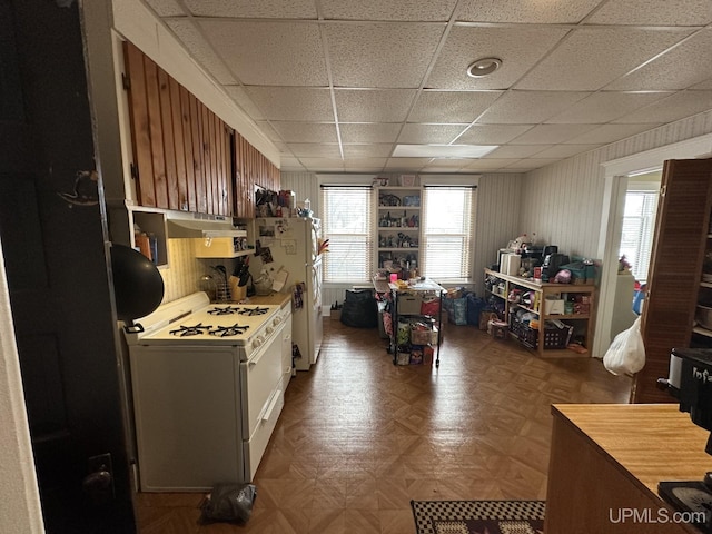 kitchen with a paneled ceiling, white appliances, and parquet flooring