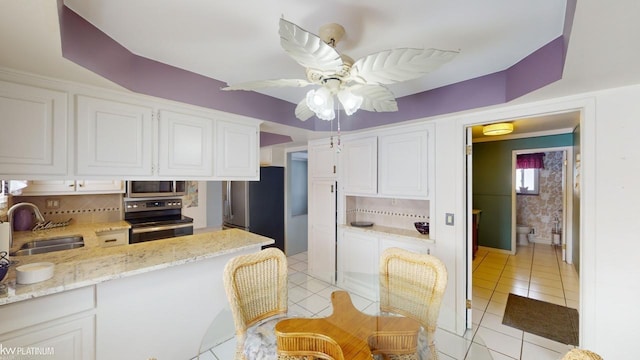 kitchen with appliances with stainless steel finishes, white cabinetry, decorative backsplash, and sink