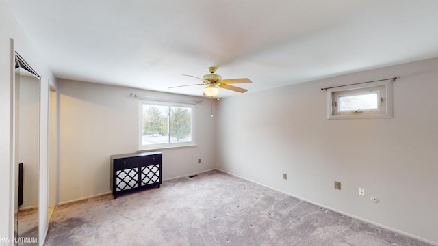 interior space with light carpet and ceiling fan