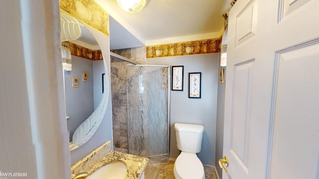 bathroom with a tile shower, vanity, and toilet