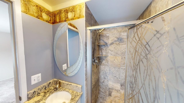 bathroom featuring a shower with door and vanity