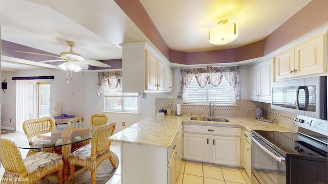 kitchen featuring sink, white cabinets, ceiling fan, light tile patterned floors, and appliances with stainless steel finishes