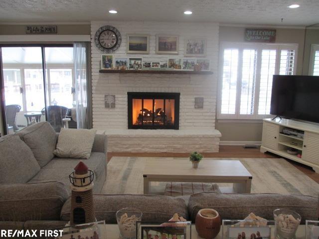 living room with hardwood / wood-style floors and a brick fireplace