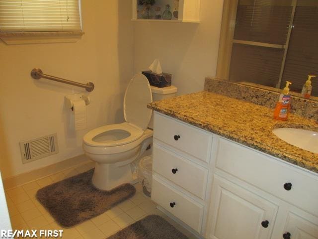 bathroom featuring vanity, tile patterned flooring, and toilet