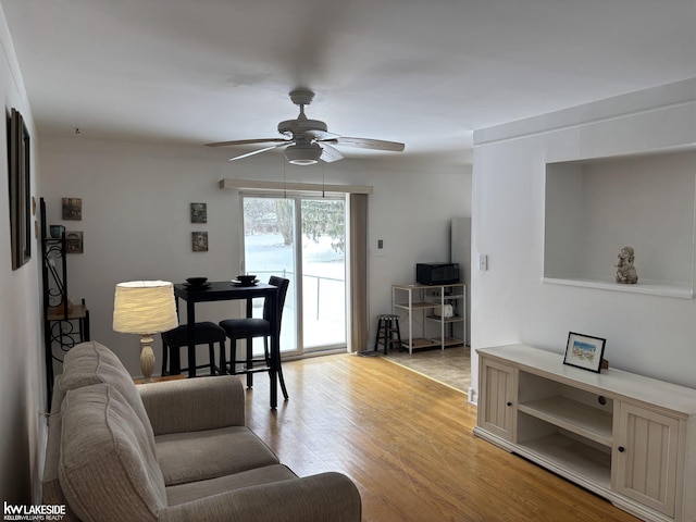 living room with light wood-type flooring and ceiling fan