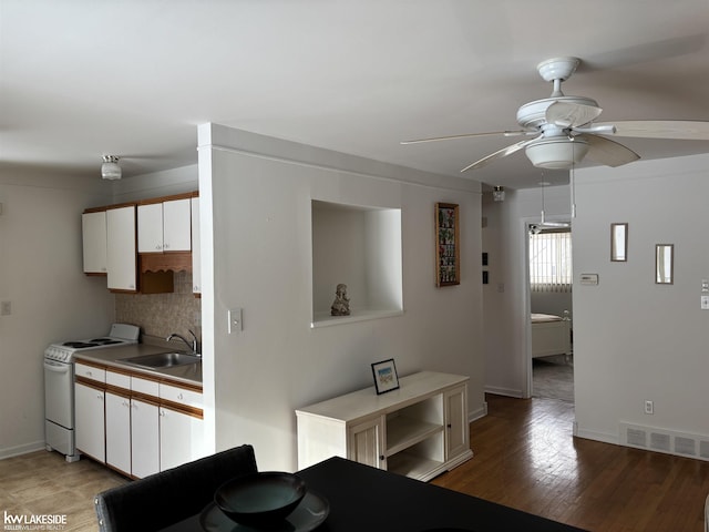 kitchen featuring sink, white cabinets, ceiling fan, white electric range oven, and decorative backsplash